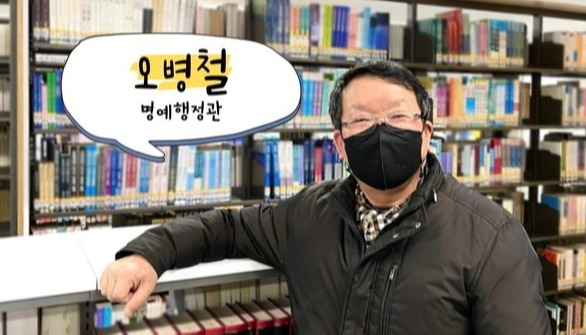 도서관 5층 자료실에서 근무중인 오병철 명예 행정관. 사진 요청에 웃음을 보이고 있다. (사진 / 김솔이 기자)